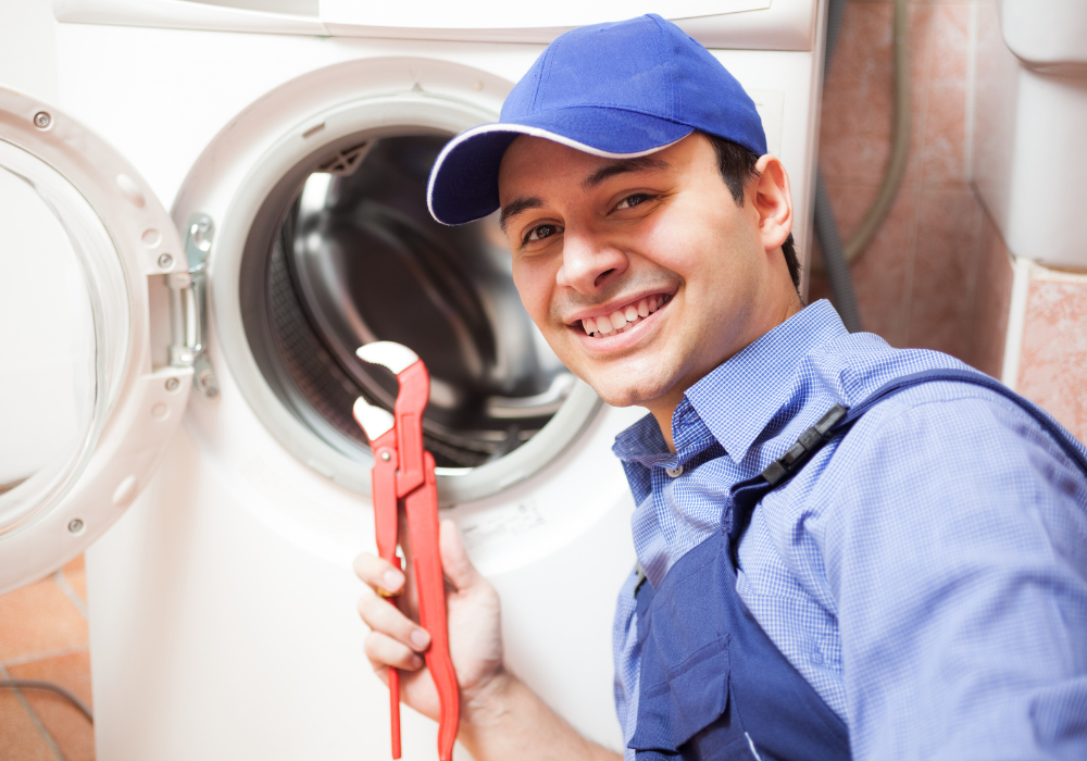 Photo d'un homme avec une clé à molette devant une machine à laver