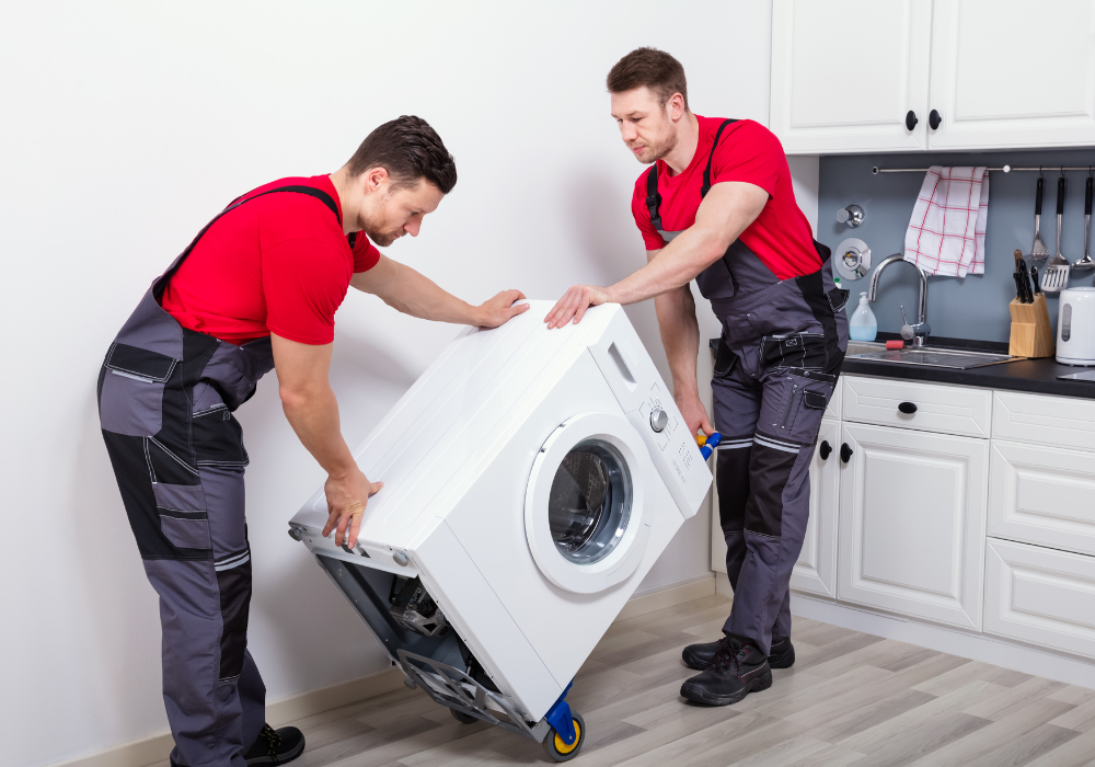 deux hommes qui déplacent une machine à laver blanche